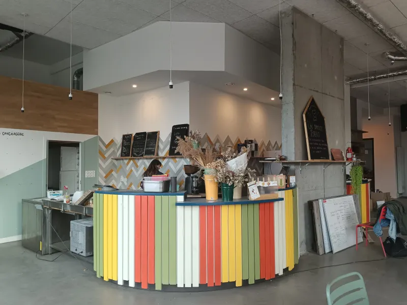 Le Labo Diva - Un bar intérieur composé de lattes de bois peintes en vert, jaune, blanc ou orange.