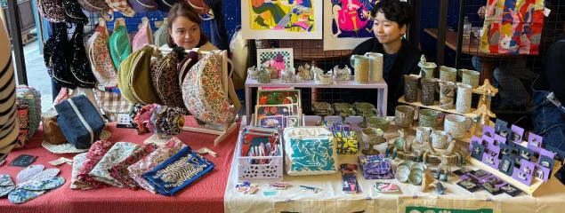 À l'intérieur du Labo Diva, un marché est installé. Des cageots de courges, blettes, patates douces, salade et autres légumes sont disposés sur des tables. Des petites pancartes noires indiquent les prix des légumes.